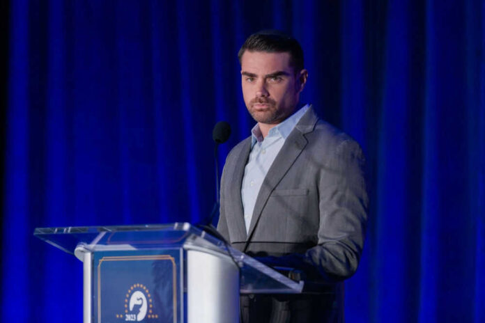 Man speaking at a podium with blue curtains