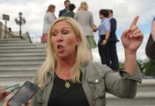 Trump’s Attack on Greene: A Dangerous Game? A woman passionately speaking outdoors, surrounded by people and media.