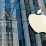 Apple logo on glass building with reflection visible