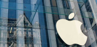 Apple logo on glass building with reflection visible