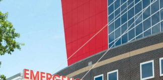 Emergency sign outside modern building with windows