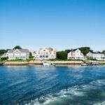 Waterfront houses along a sunny coastline with boats