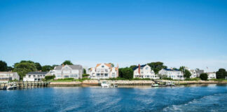Waterfront houses along a sunny coastline with boats