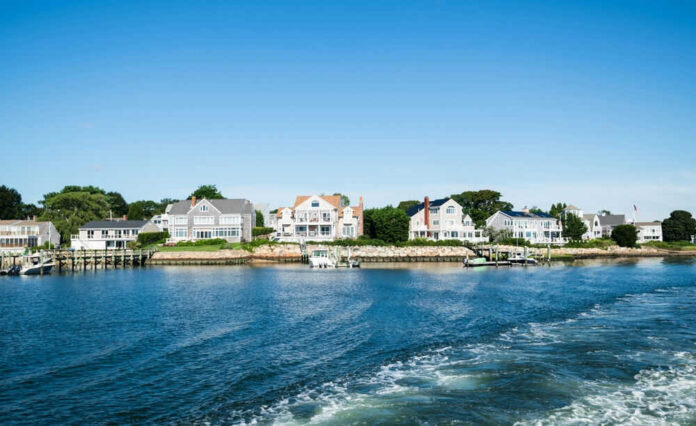 Waterfront houses along a sunny coastline with boats
