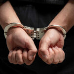 Hands in handcuffs behind persons back