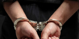 Hands in handcuffs behind persons back