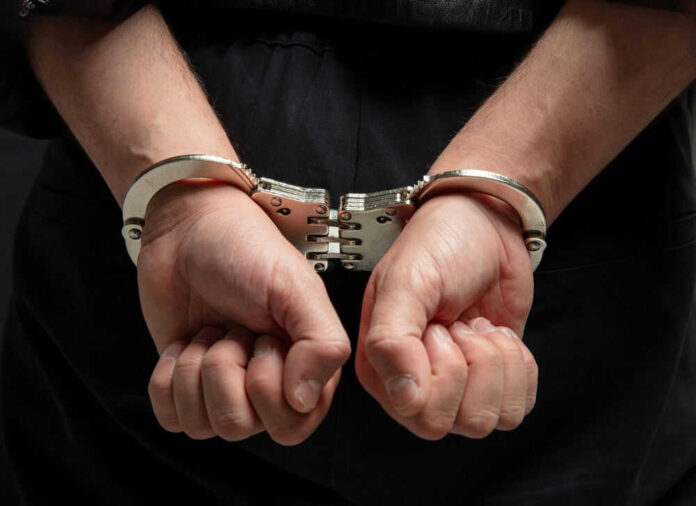Hands in handcuffs behind persons back